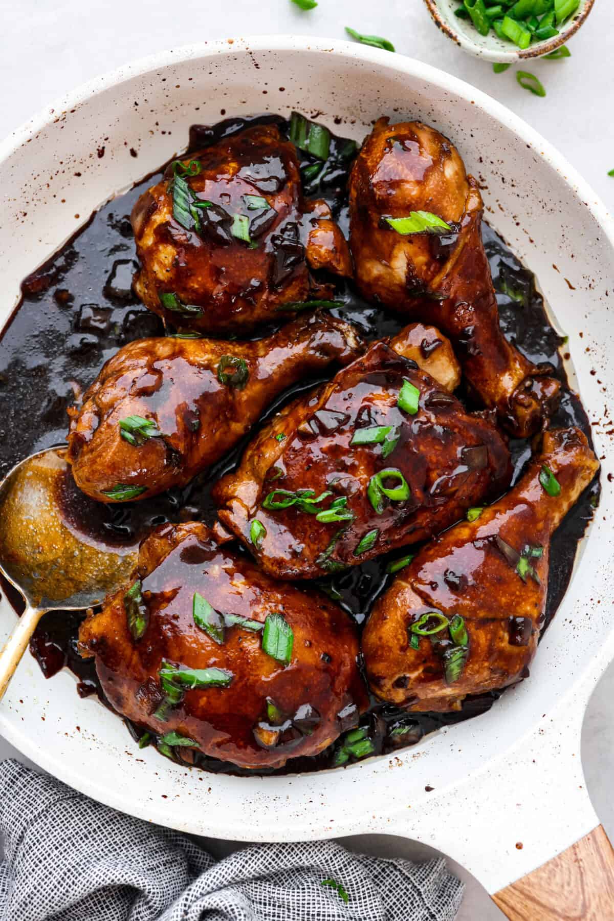Chicken Adobo is a tangy, salty, sweet, and spicy Filipino dish. This meal is easy to make and requires just a few simple ingredients. It's sure to become a family favorite! Overhead shot of chicken adobo in skillet.