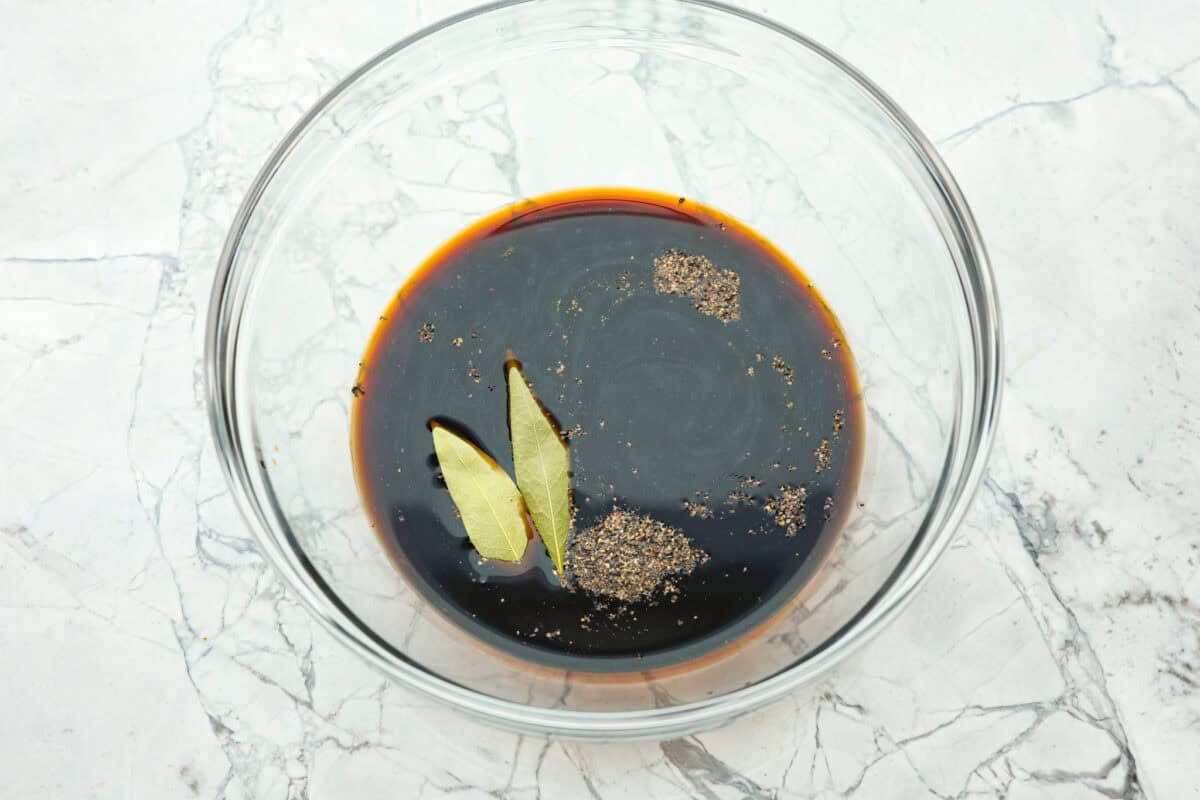 Chicken Adobo is a tangy, salty, sweet, and spicy Filipino dish. This meal is easy to make and requires just a few simple ingredients. It's sure to become a family favorite! Overhead shot of marinade ingredients in large glass bowl.