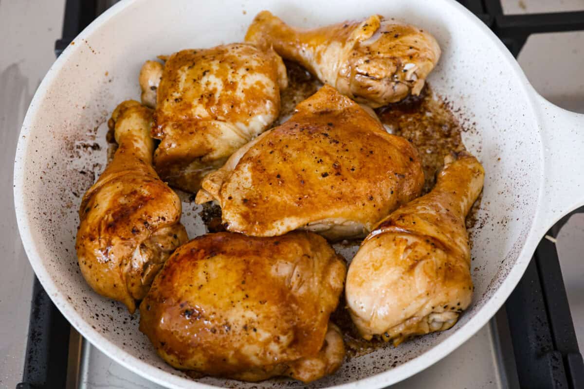 Chicken Adobo is a tangy, salty, sweet, and spicy Filipino dish. This meal is easy to make and requires just a few simple ingredients. It's sure to become a family favorite! Angle shot of chicken being browned in a skillet.