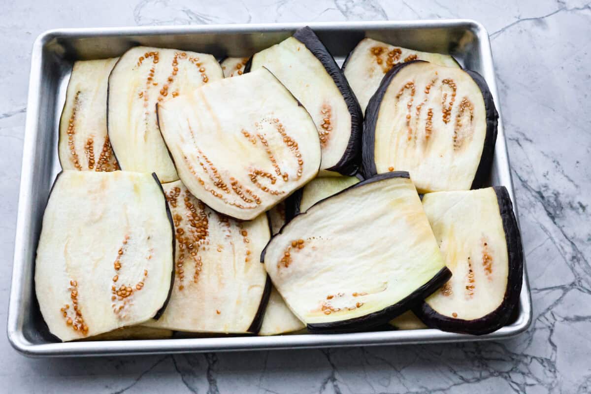 Eggplant Lasagna is a delicious low-carb way to enjoy the classic flavors of lasagna! The tender eggplant layers are loaded with meat sauce, a creamy ricotta mixture, and lots of melty cheese. You won't even miss the noodles! First photo of the eggplant slices sweating.