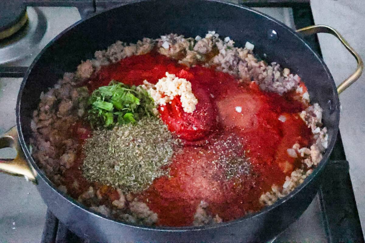 Eggplant Lasagna is a delicious low-carb way to enjoy the classic flavors of lasagna! The tender eggplant layers are loaded with meat sauce, a creamy ricotta mixture, and lots of melty cheese. You won't even miss the noodles! Third photo of the sauce ingredients added to the sausage.