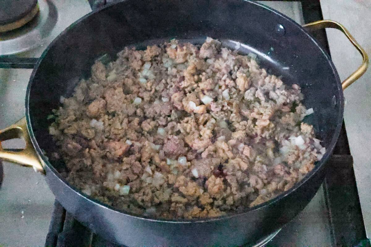 Eggplant Lasagna is a delicious low-carb way to enjoy the classic flavors of lasagna! The tender eggplant layers are loaded with meat sauce, a creamy ricotta mixture, and lots of melty cheese. You won't even miss the noodles! Second photo of the sausage and onions cooking.