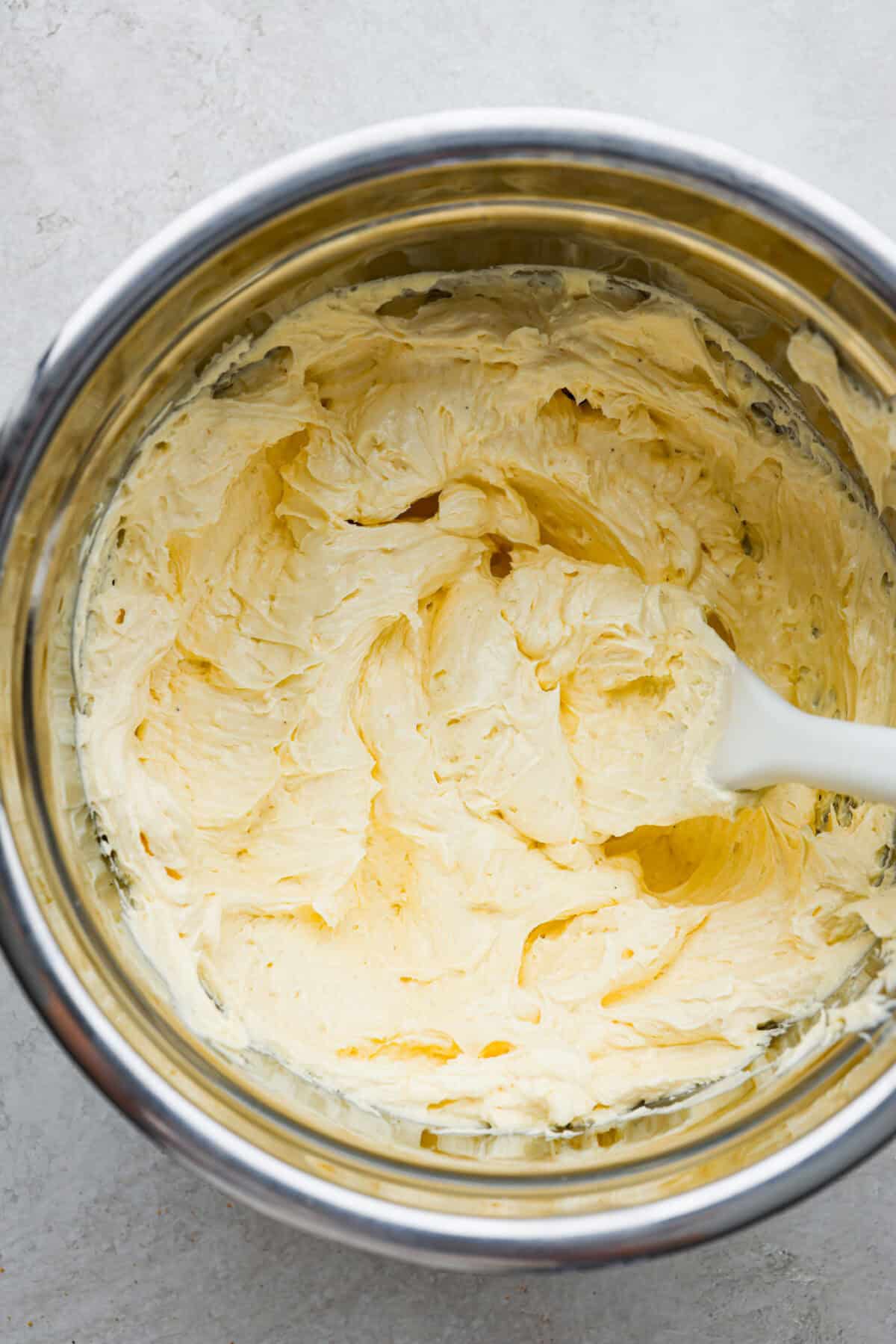 French buttercream is a luxurious, creamy frosting that will wow your guests and tantalize your taste buds. The elegant flavor comes from using egg yolks as the base and delicious, simple syrup for sweetness. Elevate your baking game with this unique recipe. Overhead shot of french buttercream in a bowl.