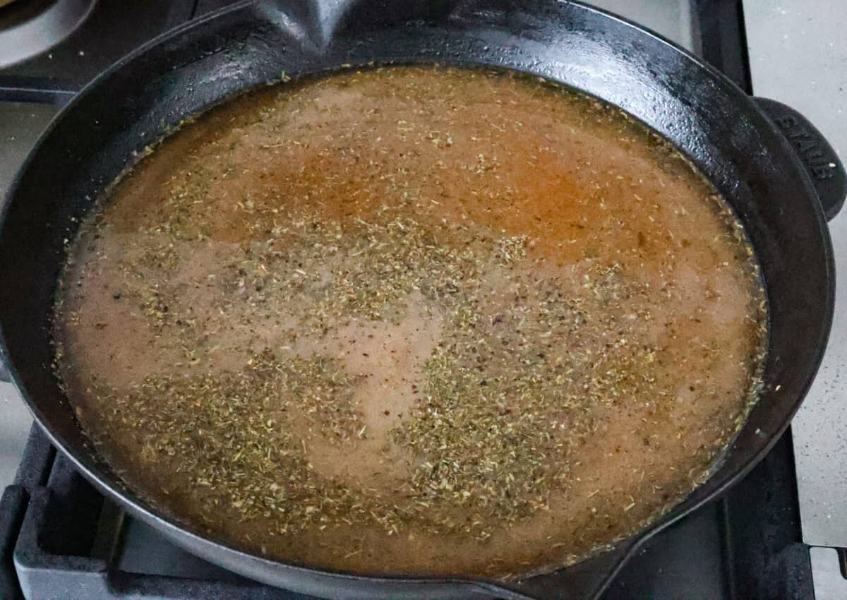 Skillet French Onion Chicken delivers a tender and creamy chicken dinner that you can make at home, it's easily better than anything you can find in a restaurant. Your family will love this incredibly delicious meal, making it an instant favorite! Overhead shot of uncooked sauce ingredients in skillet.