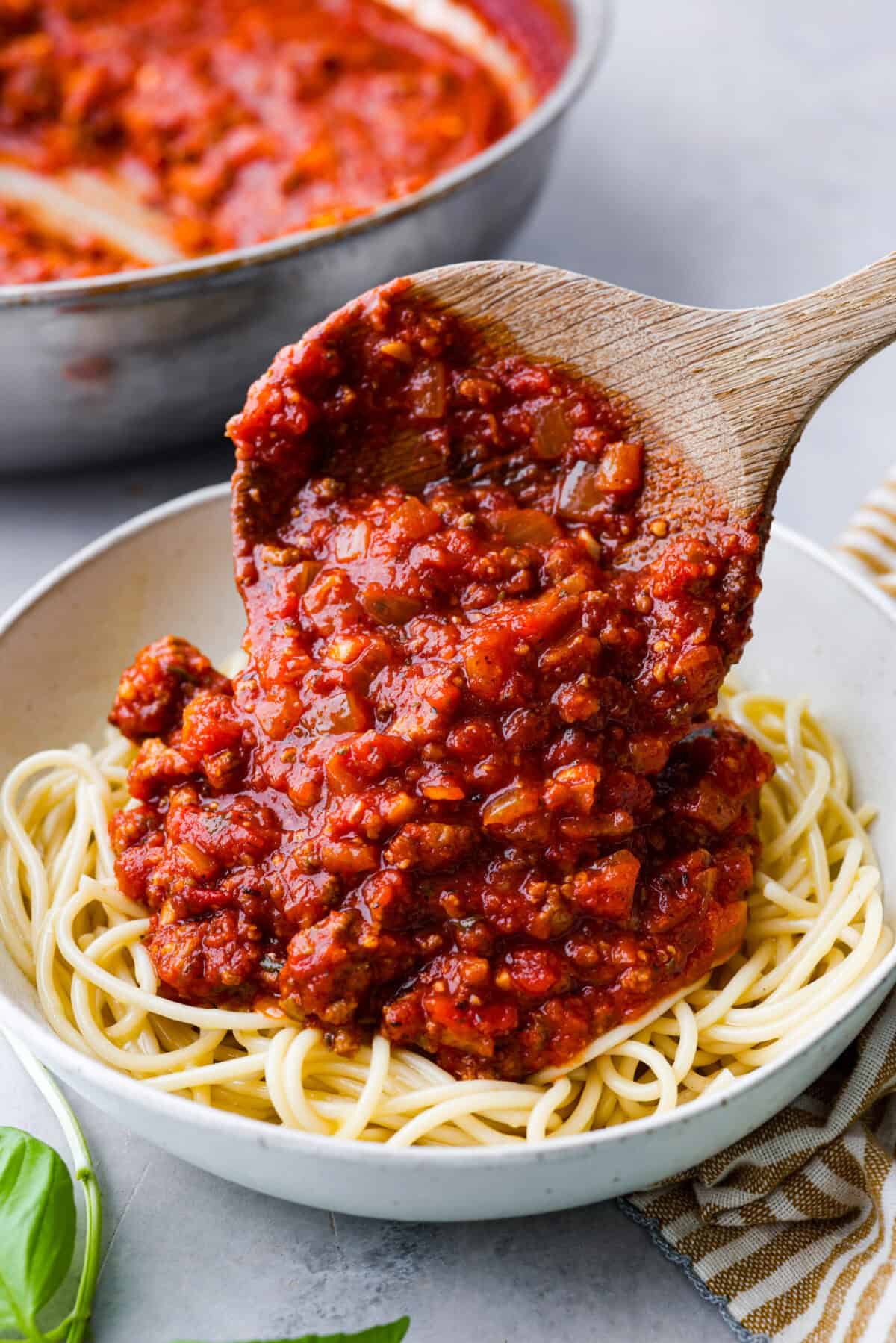 There's no need to purchase store-bought sauce, with this hearty and flavorful Homemade Spaghetti Sauce. Simple ingredients such as ground beef, onion, garlic, and spices of oregano and basil bring a bold flavor to this simple sauce. Close view of homemade spaghetti sauce spooning on top of a bowl of noodles.