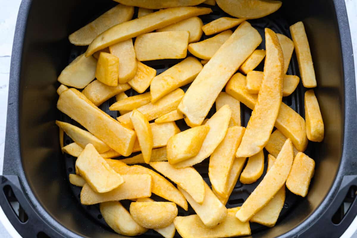 The air fryer is one of the most versatile appliances in today's kitchen! Learn how to use an air fryer to cook, reheat, and achieve that "fried" texture without frying in oil. Once you cook in the air fryer you will never look back! First photo of frozen French fries in a basket.