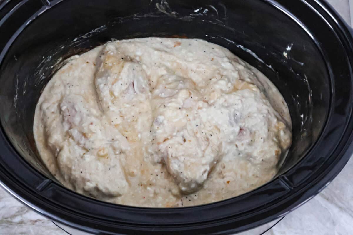 Italian cream cheese chicken is a simple way to enjoy tender, creamy, flavorful chicken over noodles, rice, or potatoes. With only four ingredients, this is definitely one of those slow cooker recipes you will have on repeat. Overhead shot of flipped chicken and mixed cream cheese sauce.