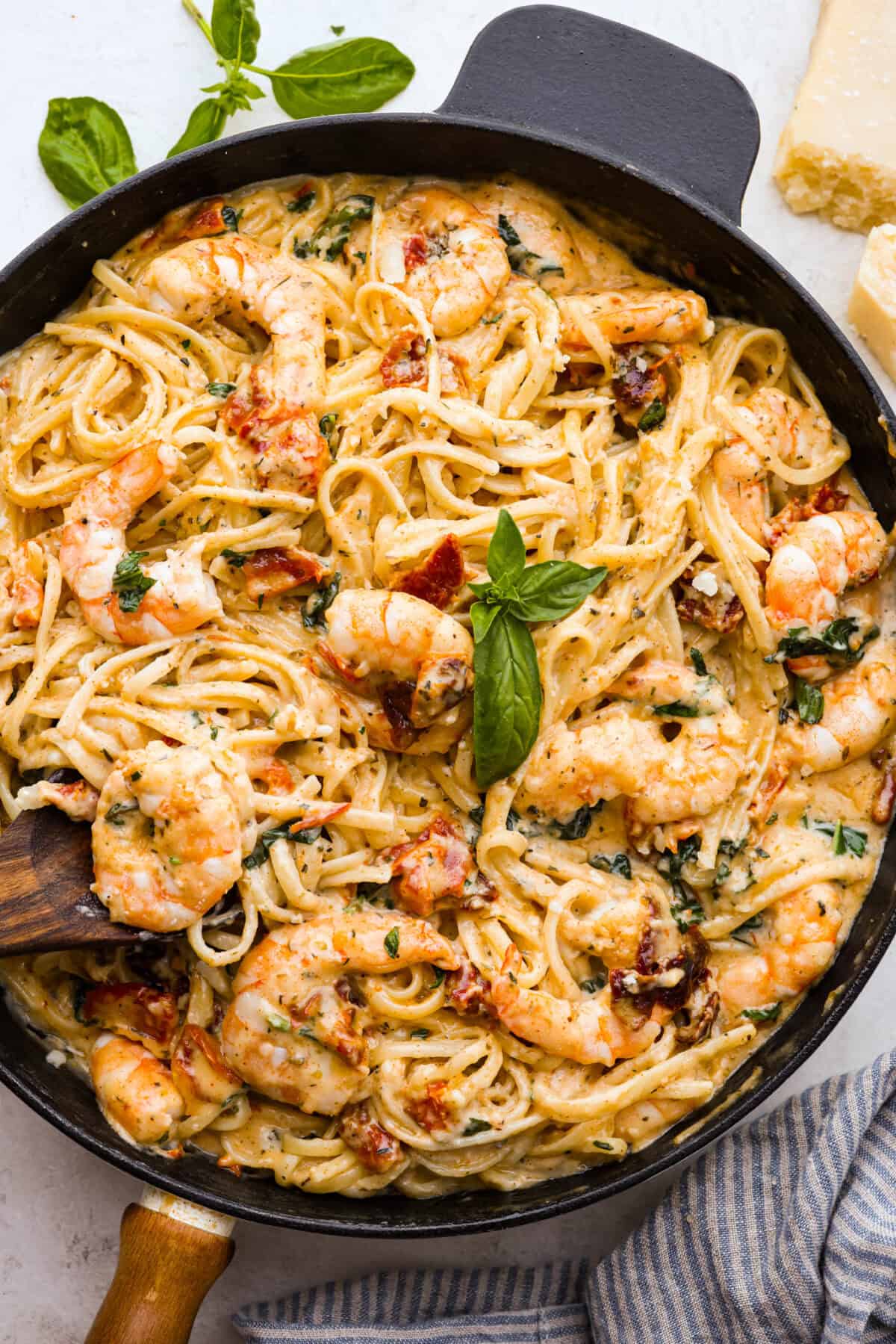 Marry Me Shrimp Pasta dazzles with robust Italian flavors. It's ready in just 30 minutes, and the creamy sauce, brimming with fresh herbs and spices, could very well lead to a marriage proposal after your first bite! Overhead close up shot of garnished marry me shrimp with pasta dish.