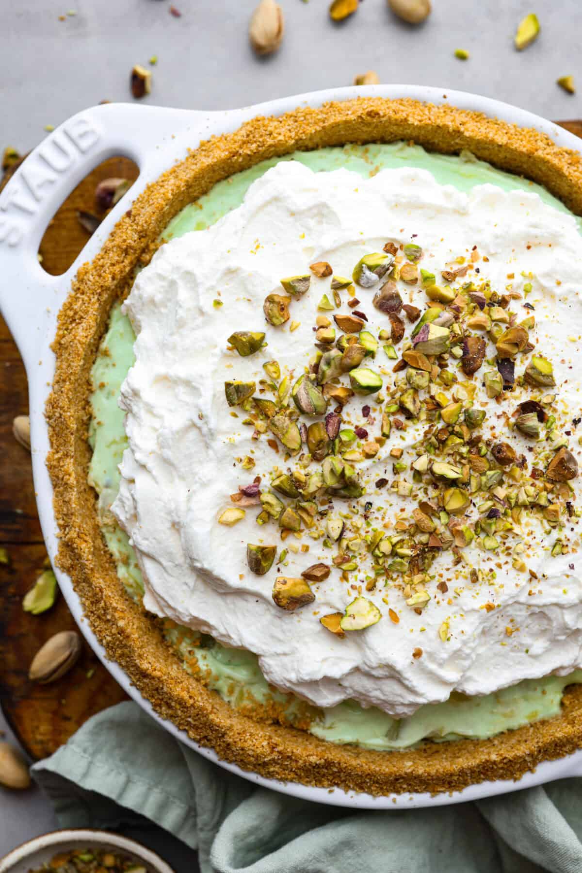 Bring this easy and irresistible no-bake pistachio cream pie to your next gathering! You'll love the combination of the pistachio and pineapple flavors that fill the inside of a sweet, buttery, graham cracker crust. Top view of the no-bake pistachio cream pie garnished with pistachios.