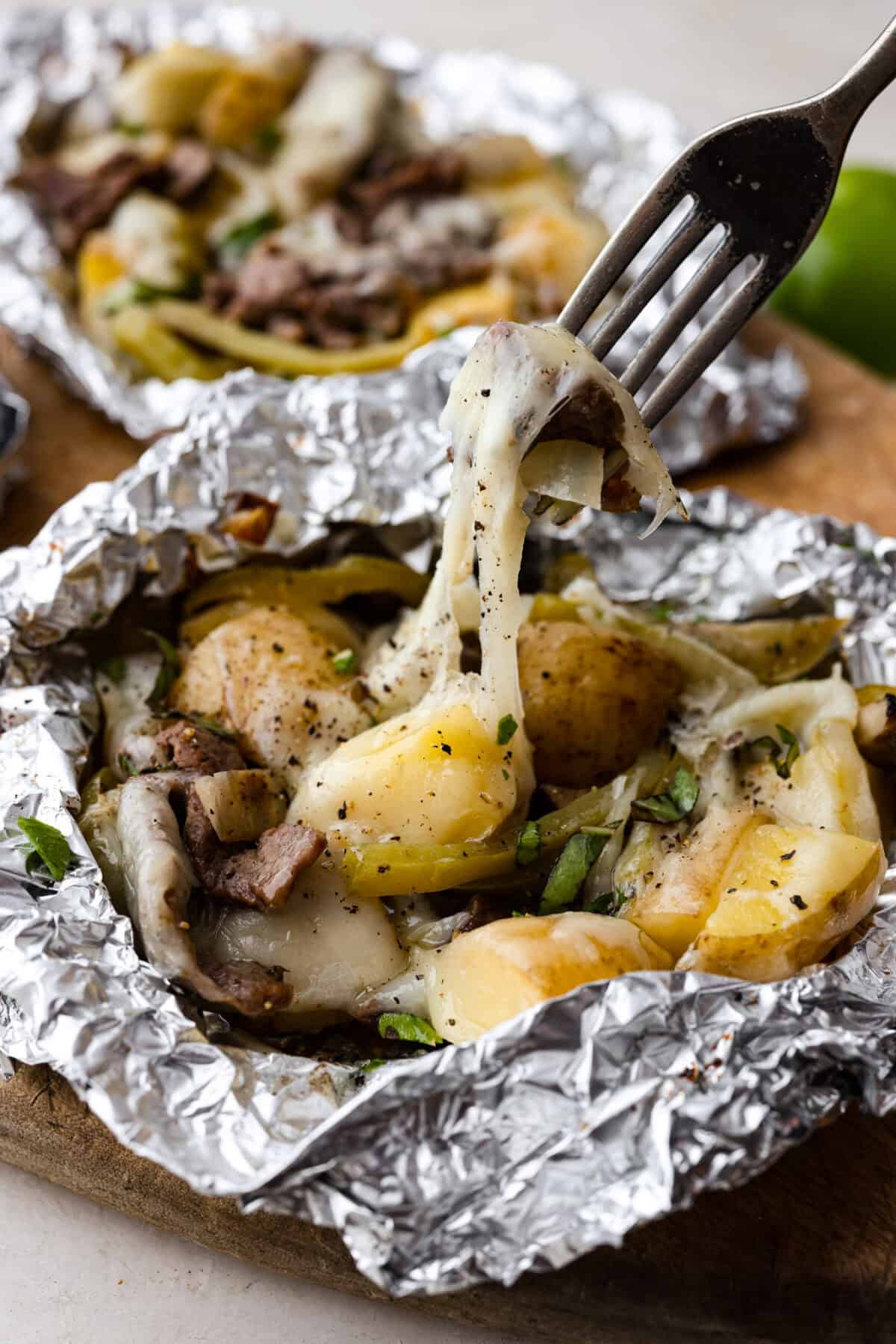For a delicious chicken version, substitute the steak with thinly sliced chicken breasts or tenders. Adjust the cooking time accordingly for perfect tenderness. Close up shot of a fork lifting a bit of the cooked cheesesteak mixture with melty cheese stretching.