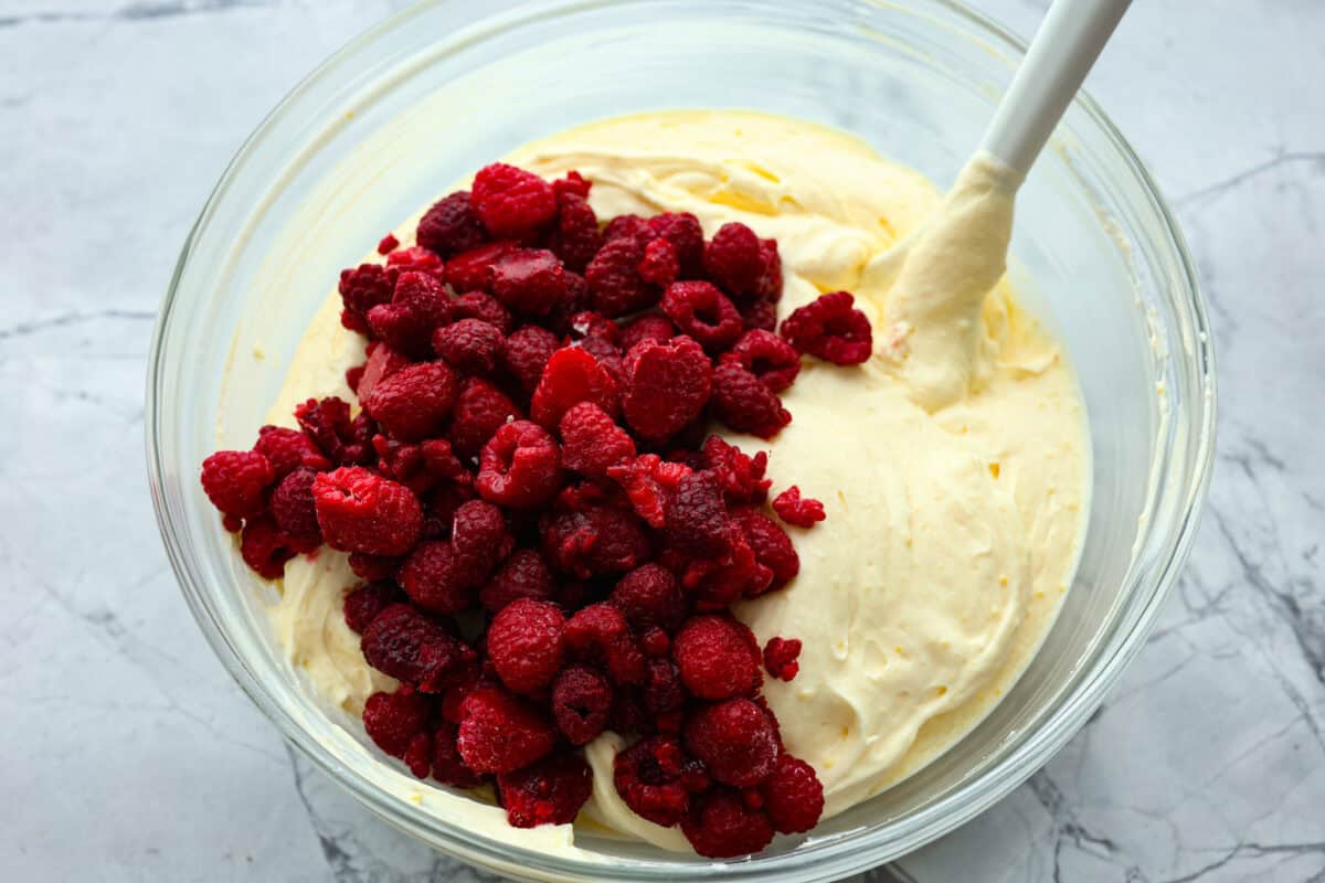 Fresh and fruity Raspberry Fluff Salad is a sweet and creamy side or dessert with a mix of raspberries, vanilla yogurt and Cool Whip. Made with just 4 ingredients in 5 minutes, it's SO easy to make and perfect for potlucks and picnics! Raspberries added to the raspberry fluff salad mixture.