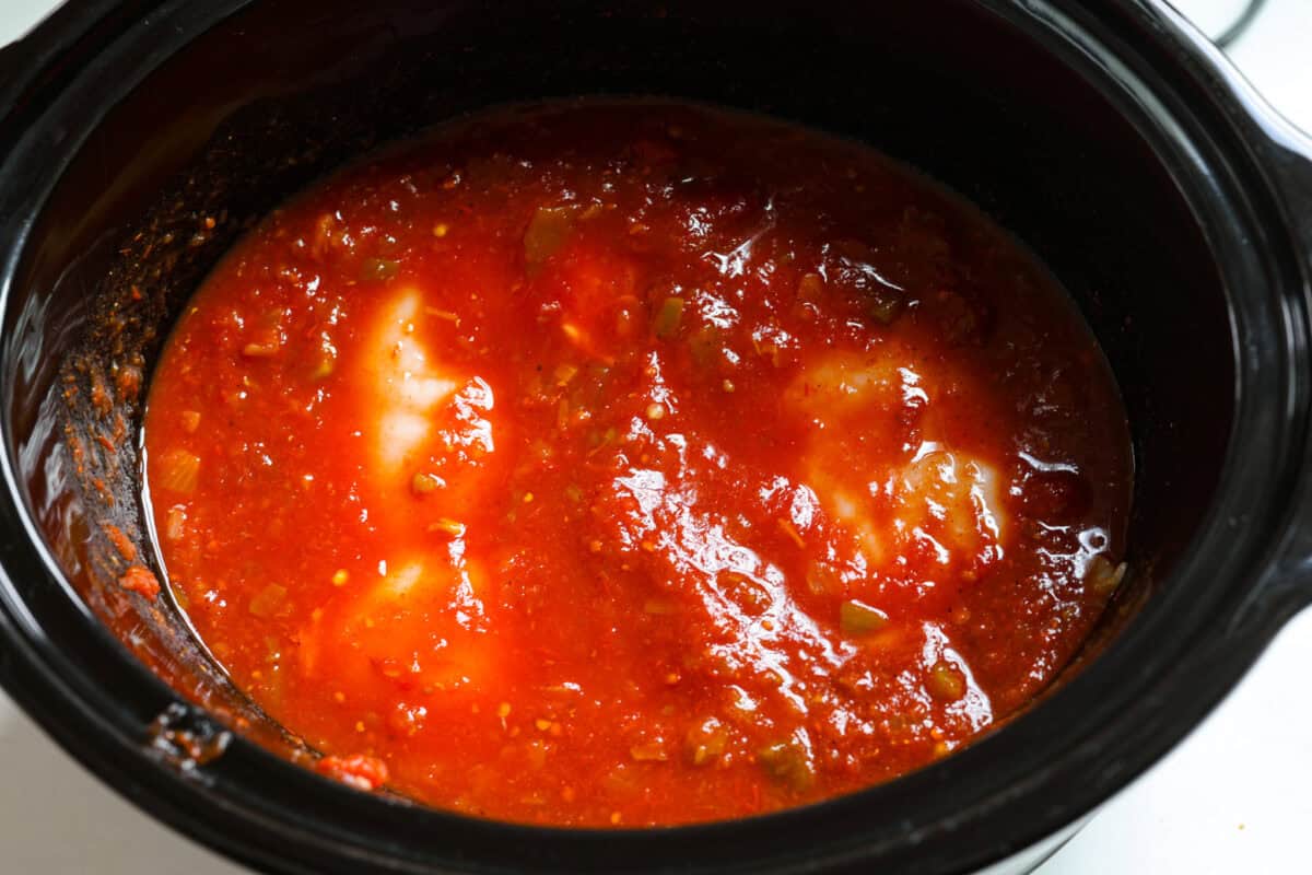 This is the BEST sweet pork taco recipe! It tastes just like Cafe Rio's famous sweet pork, with a blend of sweet and tangy flavors that melt into tender, juicy meat. It's perfect for tacos, salads, burritos, nachos, and anything else you can dream up! Overhead shot of all of the sweet pork taco ingredients in the crock pot.