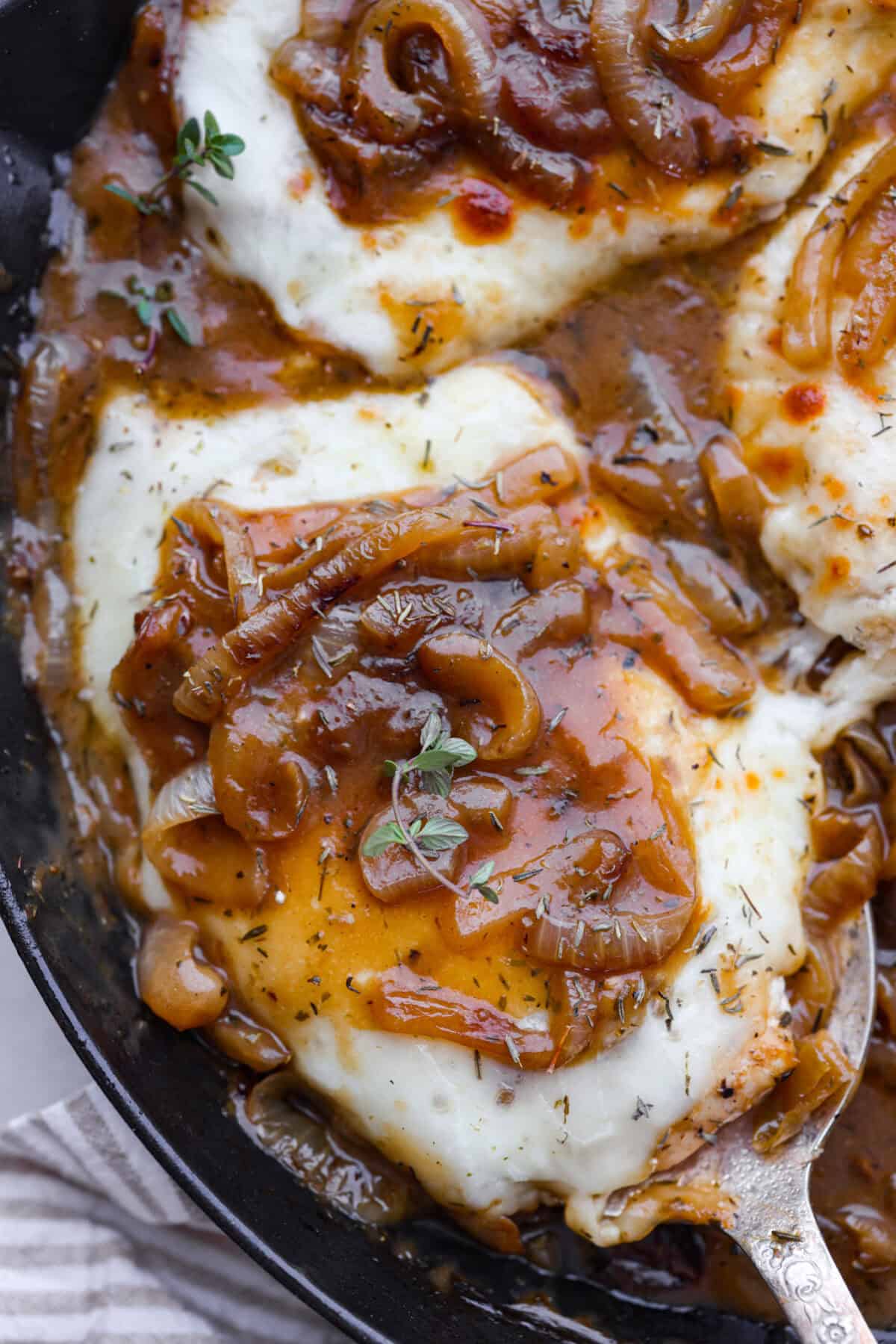 Skillet French Onion Chicken delivers a tender and creamy chicken dinner that you can make at home, it's easily better than anything you can find in a restaurant. Your family will love this incredibly delicious meal, making it an instant favorite! Close up shot of finished skillet french onion chicken.