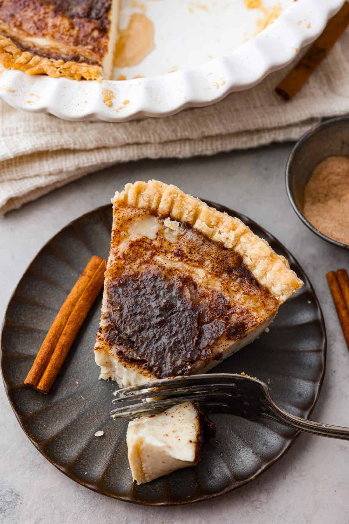 Sugar cream pie, or Hoosier pie, is a creamy, delicious treat with deep roots in the Midwest, especially in Indiana. You can top it however you like, serve it warm, at room temperature, or even chilled. Give this simple recipe a go. I know youโll love it! Overhead shot of a slice of sugar cream pie plated with a fork and a bite cut out of it.