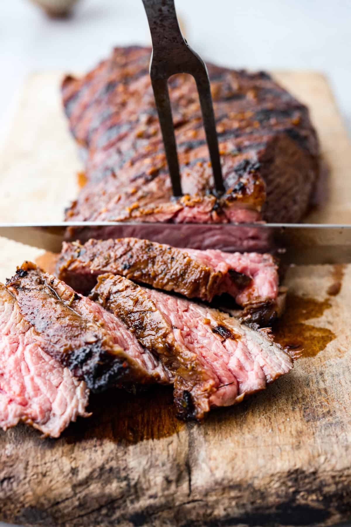 Close up shot of raw tri-tip in large zip-loc with marinade being poured over it. Close up shot of slicing the meat.