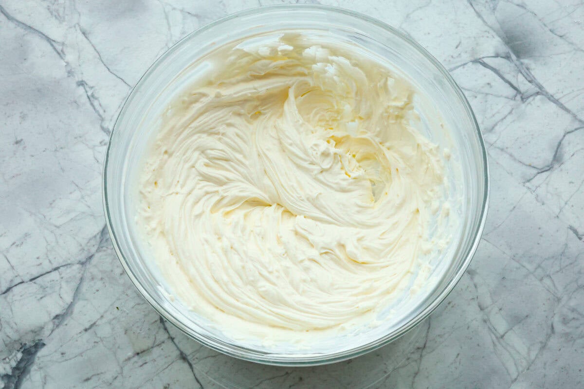 There's a new appetizer in town, and this creamy Tuscan dip won everyone's hearts! The combination of cheeses, garlic, spinach, and sun-dried tomatoes creates an addicting dip you’ll want to bring to all of your gatherings! First photo of the cream cheese and sour cream mixed in a bowl.