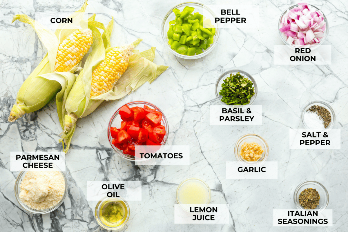 This Italian Corn Salad is bursting with fresh flavors from sweet corn, juicy grape tomatoes, crisp green bell pepper, and sharp parmesan cheese. Tossed in a zesty homemade Italian dressing, it’s perfect for summer or any time of the year. Overhead shot of labeled ingredients.