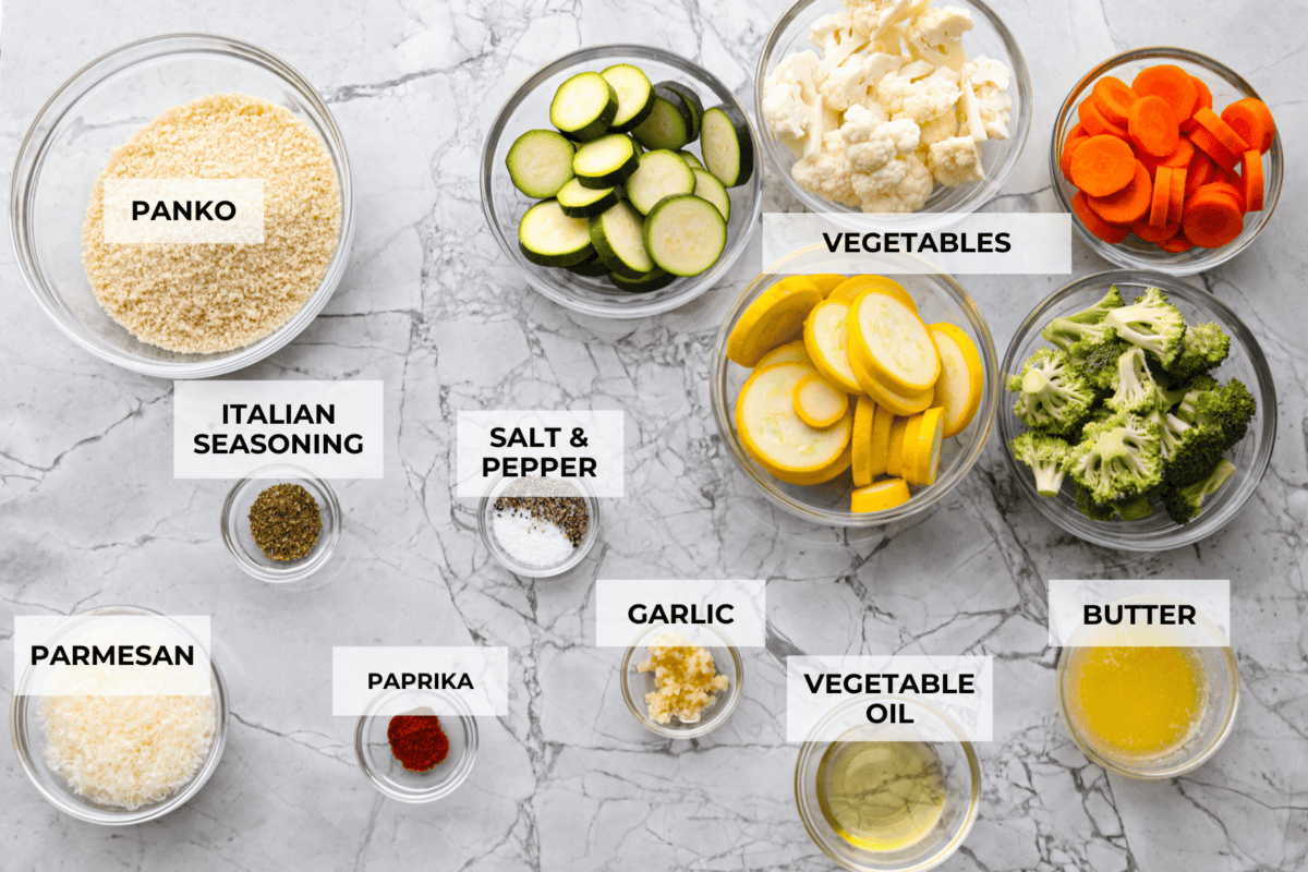 These delicious parmesan roasted vegetables are coated in zesty Italian dressing and a crispy parmesan mixture that delivers incredible flavor. This recipe cooks quickly and works with any vegetable you have on hand, whether using zucchini, cauliflower, or squash. Simply choose your favorite veggies! Overhead shot of labeled vegetables.