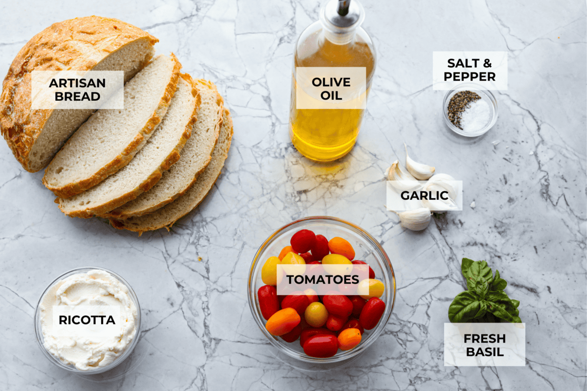 Vibrantย Tomato Toastย has sweet, juicy tomatoes, garlic, creamy ricotta, and fresh basil layered on a crusty slice of toasted bread. Itโs delicious and savory with hints of sweetness. Serve it for breakfast, brunch, as an appetizer, or light lunch for the perfect way to use up summer produce. Overhead shot of labeled ingredients.