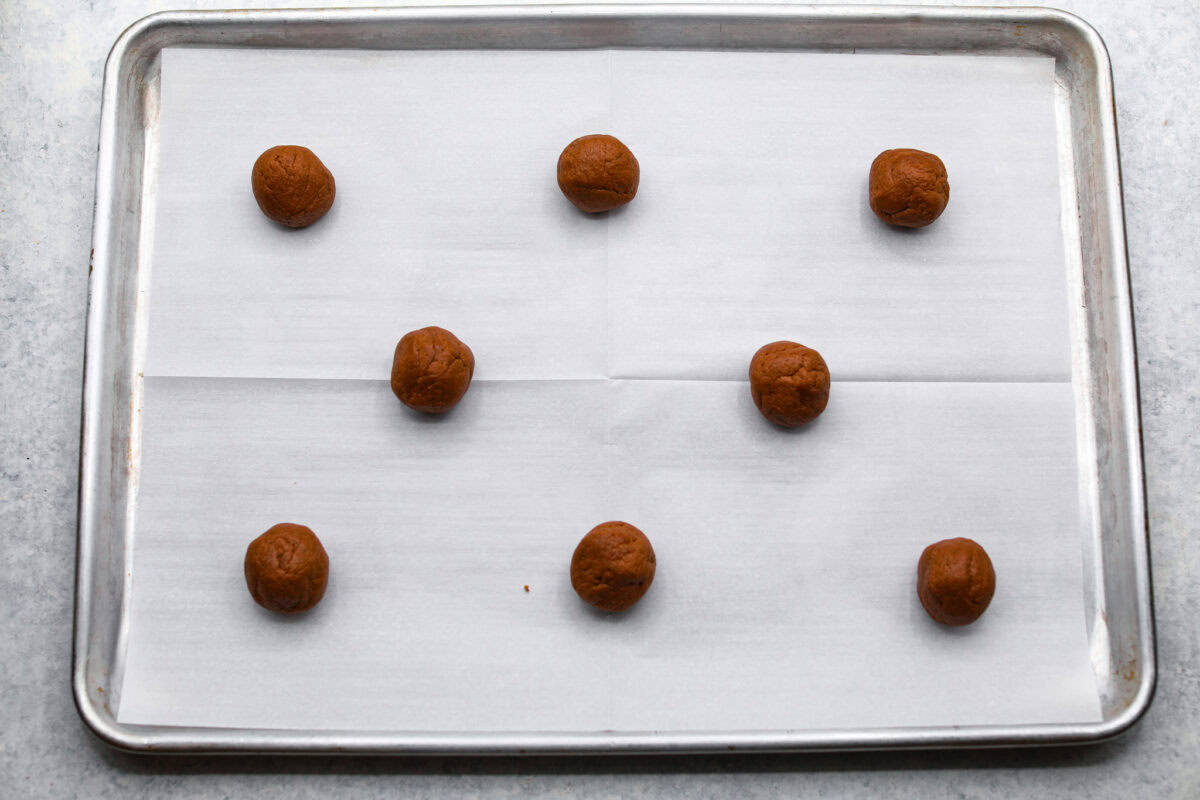 Chocolate Pudding Cookies are soft, chewy, and irresistibly delicious! They are quick and easy to bake and will be a huge hit with anyone who tries them! Cookie dough balls on a baking sheet with parchment paper.