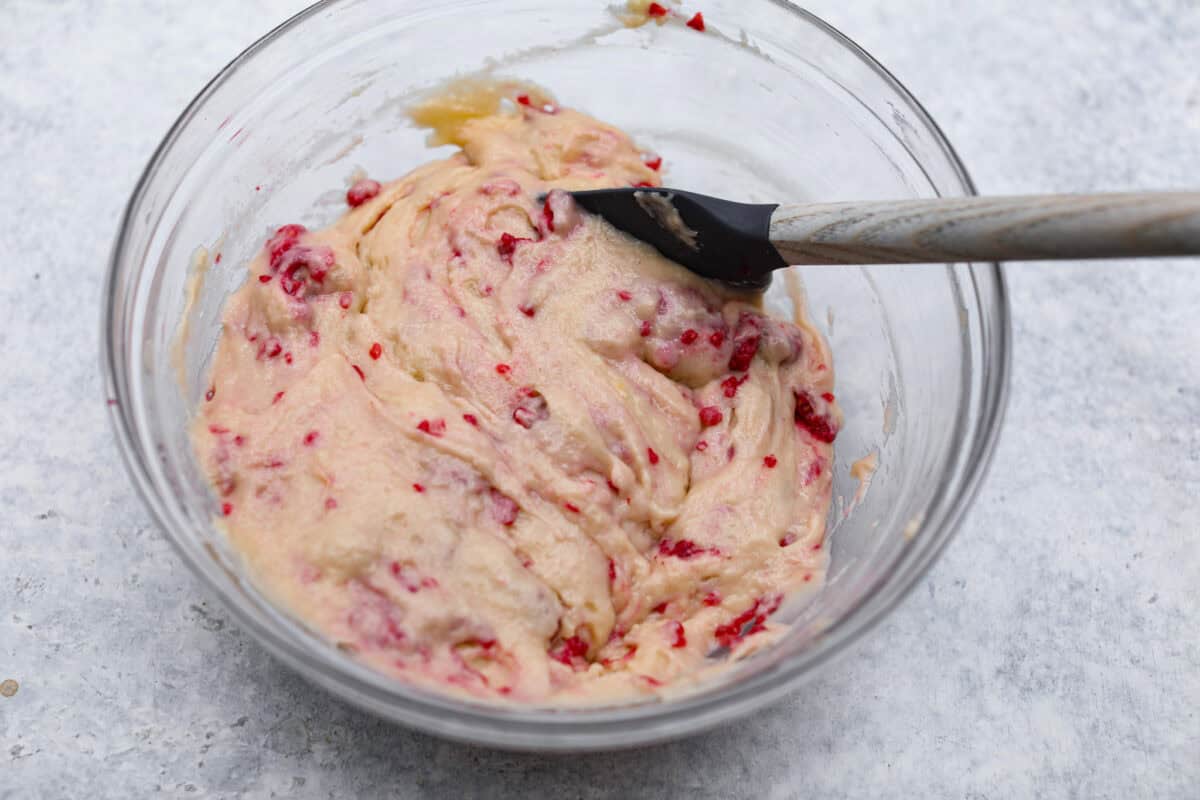 These raspberry muffins are moist and delicious, filled with plump fresh raspberries and topped with a sweet, crunchy streusel topping! They are perfect for a warm breakfast, brunch, or as an after-school or work snack. Your family will be begging for more, so donโt expect them to last long! Overhead shot of raspberries folded into the muffin batter.