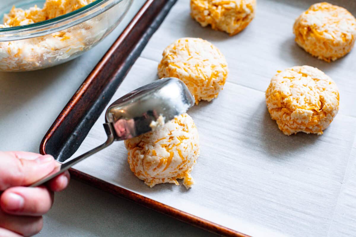 These delicious Copycat Red Lobster Cheddar Bay Biscuits are better than the real thing! Warm, buttery, and ready in 20 minutes! Third photo of the biscuit dough shaped onto a baking sheet.
