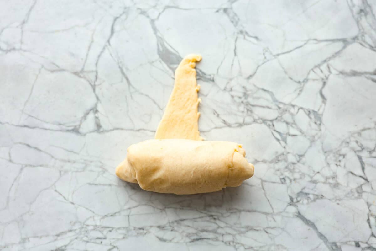 Pizza Stuffed Crescent Rolls areย loaded with gooey mozzarella cheese and pepperoni. Serve with warm marinara for dipping! Overhead shot of rolled up crescent triangle.
