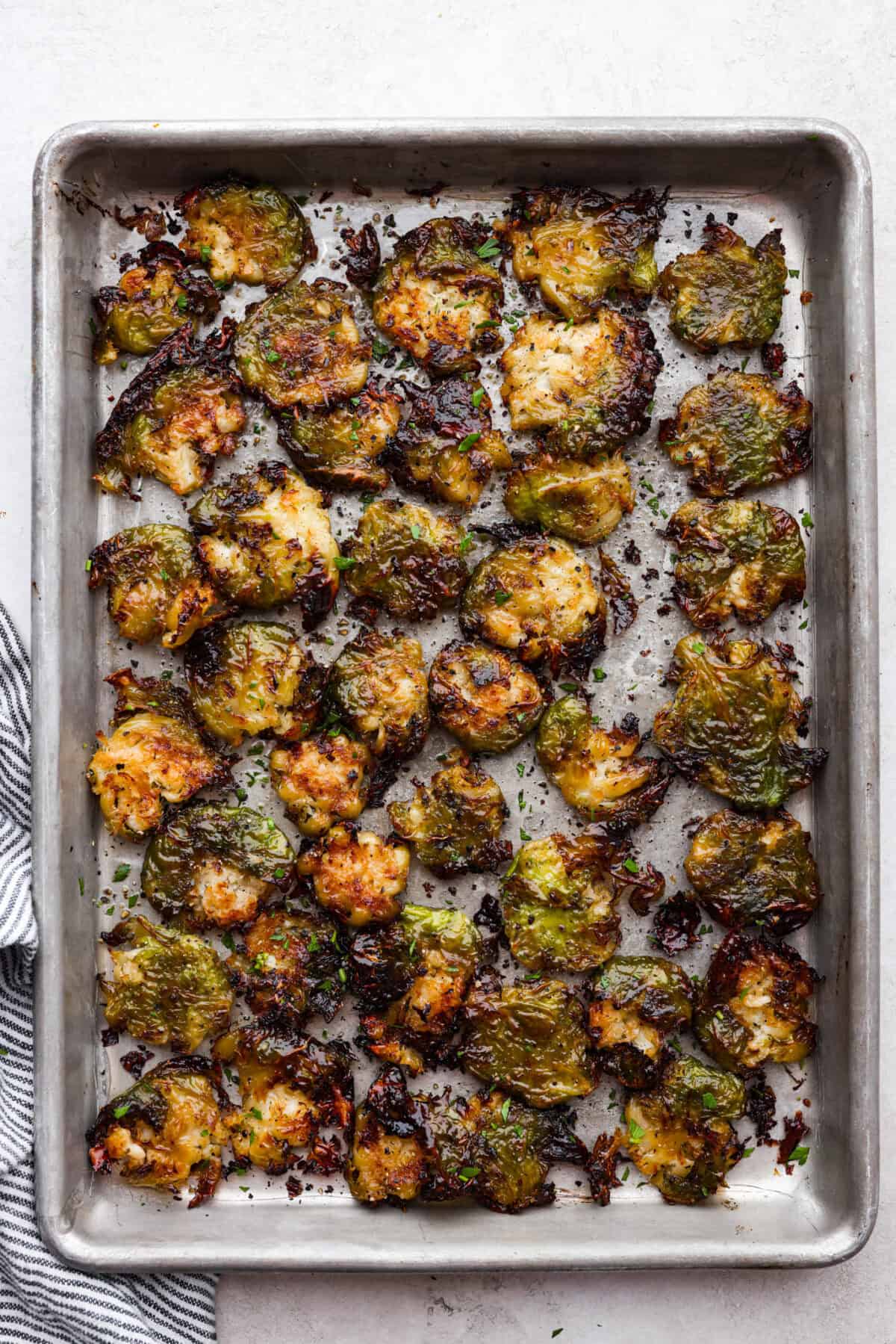 Irresistibly crispy Smashed Brussels Sprouts areย simple to make, loaded with delicious flavor, and have the best crunchy texture. These pair well with almost any protein and will definitely upgrade your side dish game! Overhead shot of roasted smashed Brussels sprouts on a baking sheet.