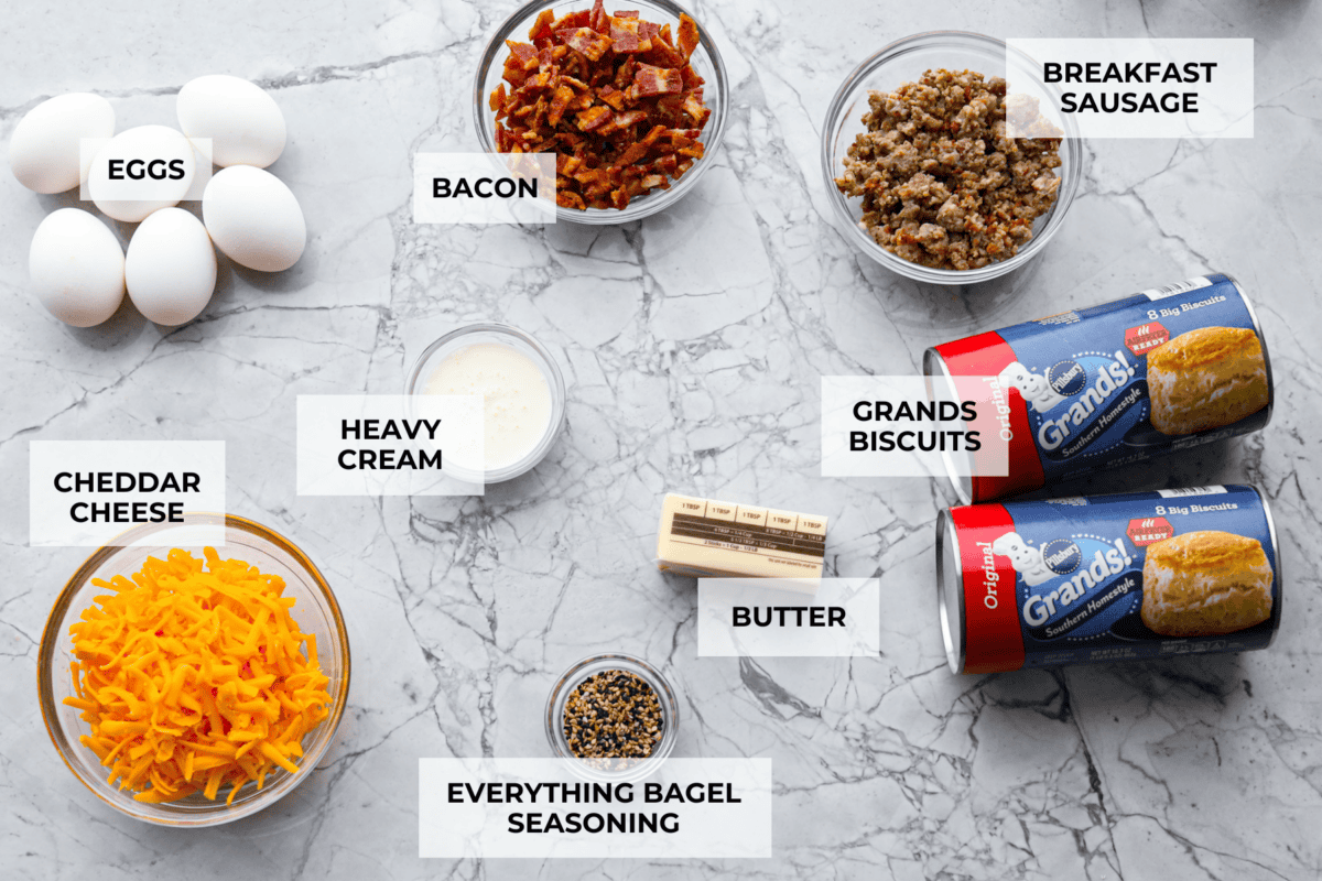 Rise and shine to Breakfast Monkey Bread with delicious savory flavors! It’s made with Grands biscuits, eggs, sausage, bacon, and cheese, all baked in a bundt pan. The result is crowd-pleasing pull-apart bread that everyone will devour! Overhead shot of labeled ingredients.