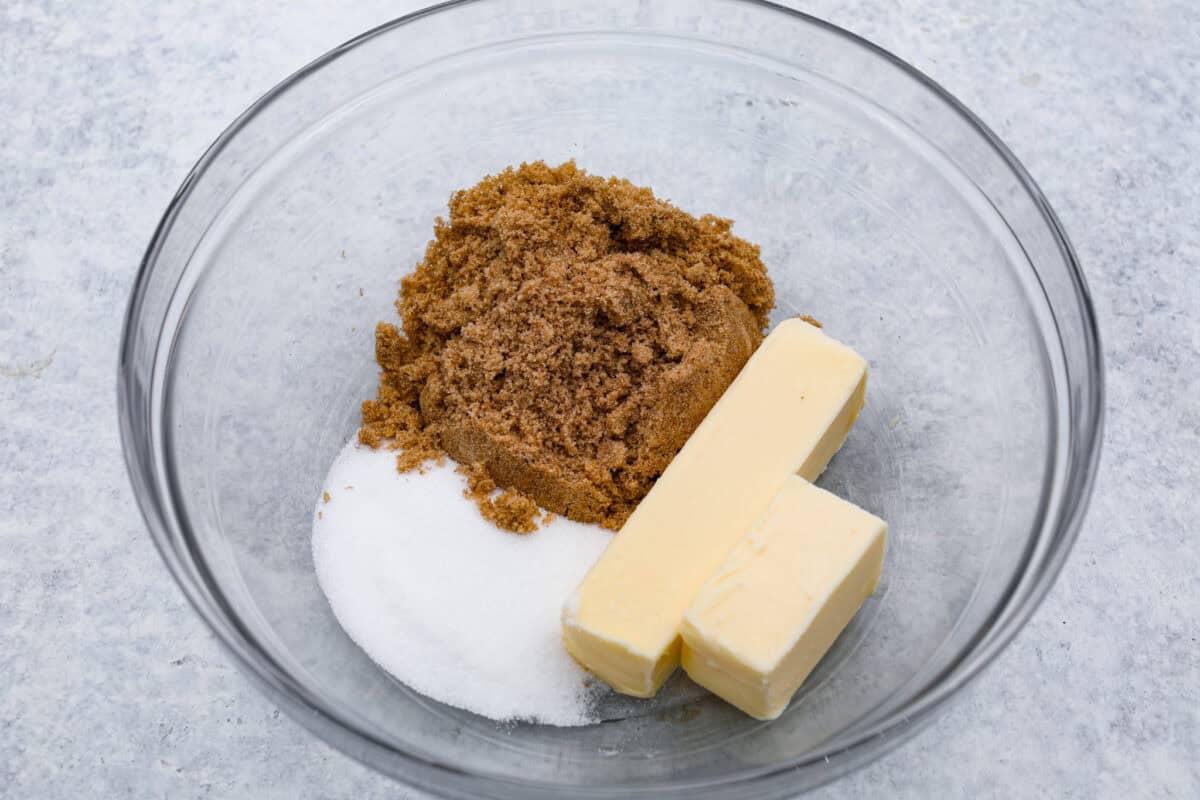 Pistachio Pudding Cookies are super soft, chewy, and irresistible! They're easy to make, and adding pistachio pudding mix gives this cookie recipe wonderful flavor and the perfect tender texture! Overhead shot of butter and sugars separated in a mixing bowl.