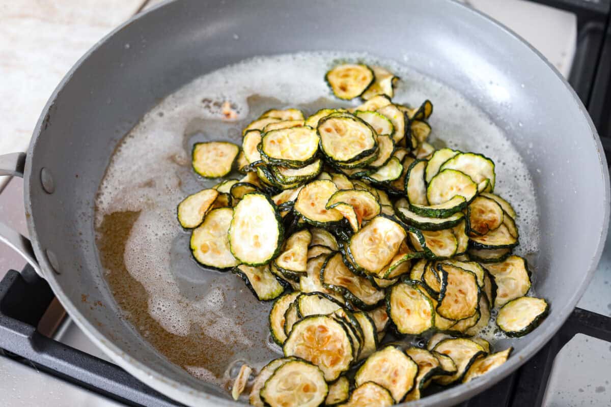 Spaghetti alla Nerano is an unforgettable pasta dish packed with flavor! It has a rich and creamy zucchini sauce infused with garlic, fresh basil, and melted cheese. Fourth photo of the chilled fried zucchini added to the skillet.
