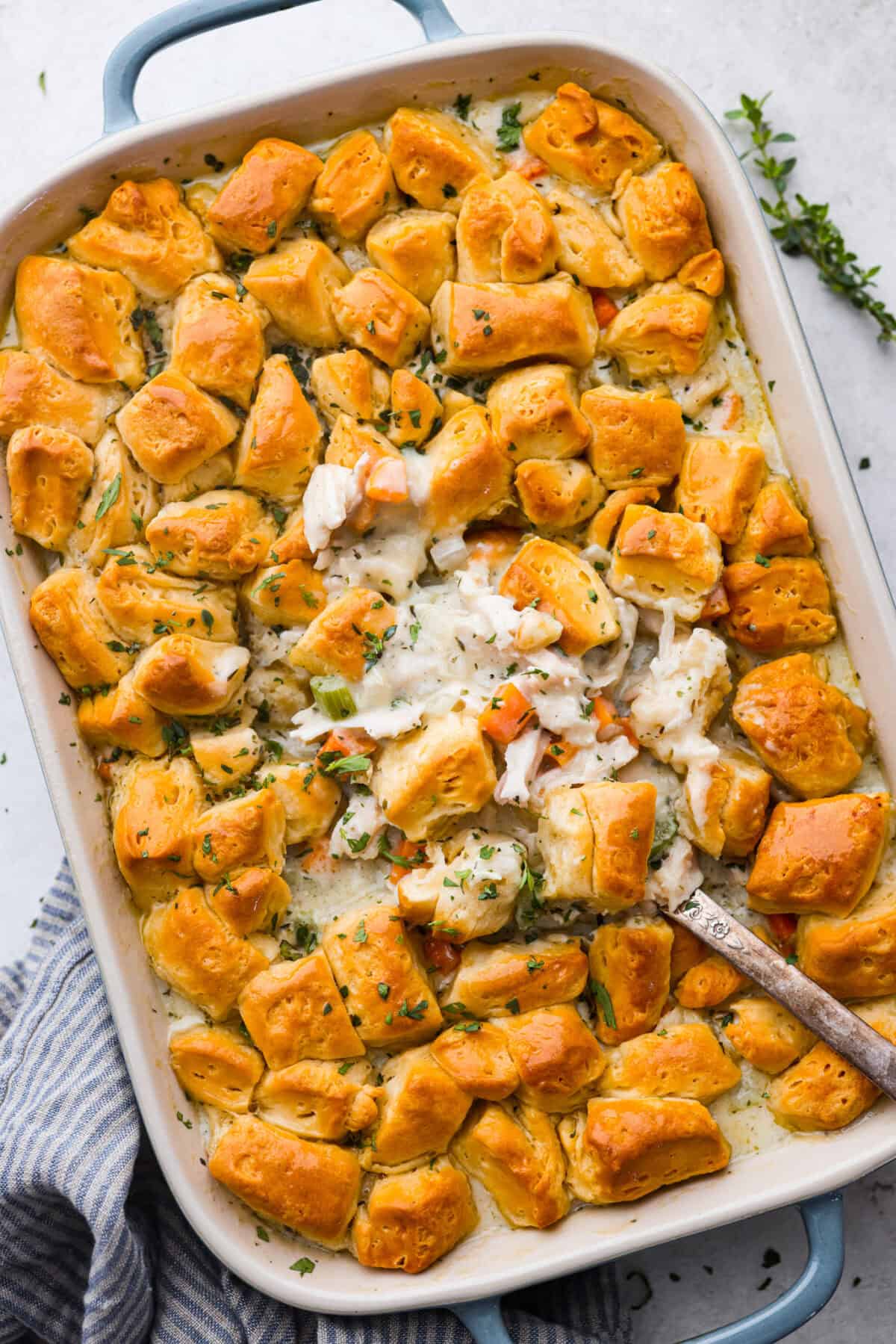 Chicken pot pie casserole is a fun twist on the classic pot pie. It's made with buttery biscuit dough, tender chicken, crunchy veggies, and the most delicious creamy sauce loaded with incredible seasoning. Comfort food at its finest! Overhead shot of baked chicken pot pie casserole.