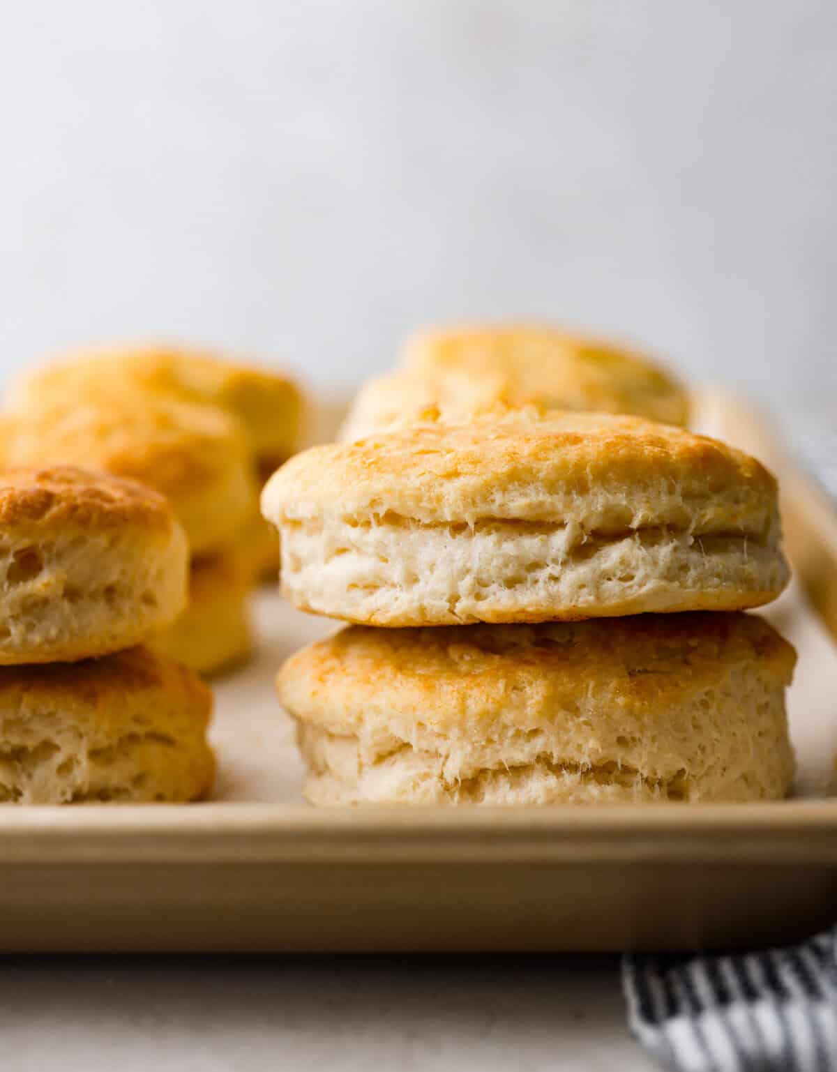 Cream cheese biscuits have a slight twist to the classic version. With the added cream cheese, they have a softer, more fluffy texture with an added tangy flavor that is so good! Close up shot of stacked cream cheese biscuits.