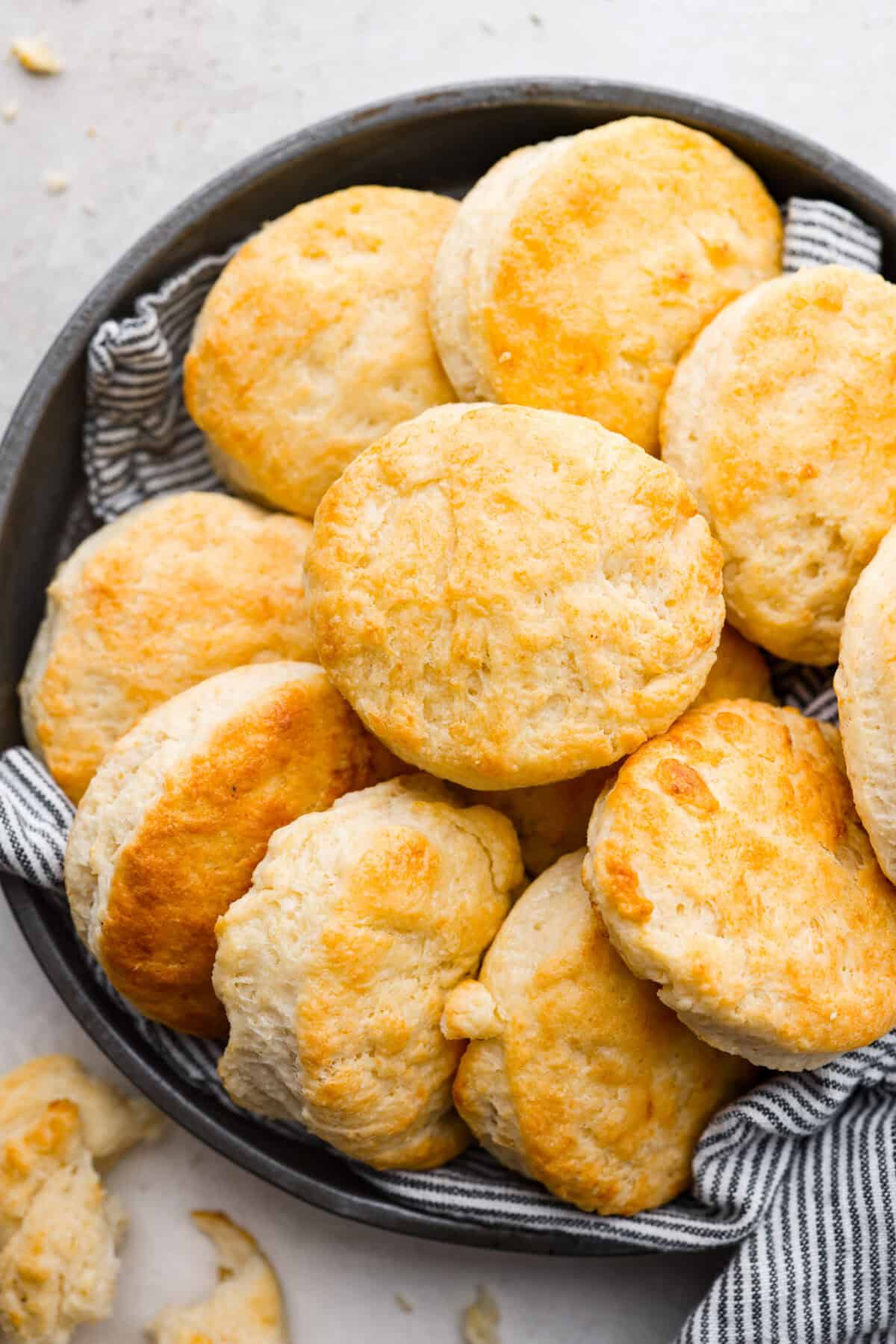 Cream cheese biscuits have a slight twist to the classic version. With the added cream cheese, they have a softer, more fluffy texture with an added tangy flavor that is so good! Overhead shot of cream cheese biscuits on a plate.