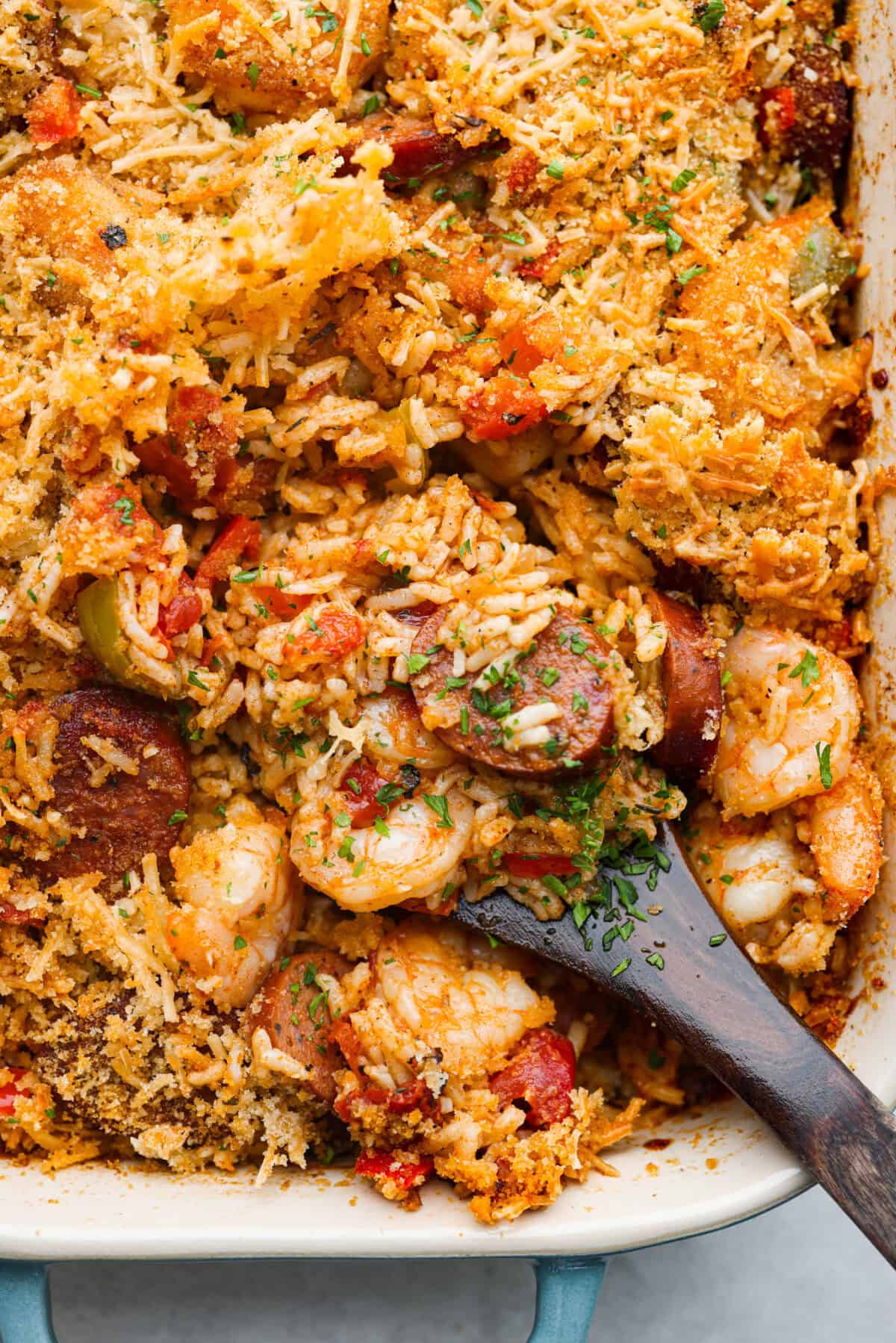 This delicious Louisiana Casserole has become an instant favorite in our house! It has all of the delicious flavors of a jambalaya in an easy-to-make casserole. Tasty andouille sausage, shrimp, veggies, rice and cajun seasoning come together for a complete meal on the table in just 40 minutes! Close up shot of baked Louisiana casserole.
