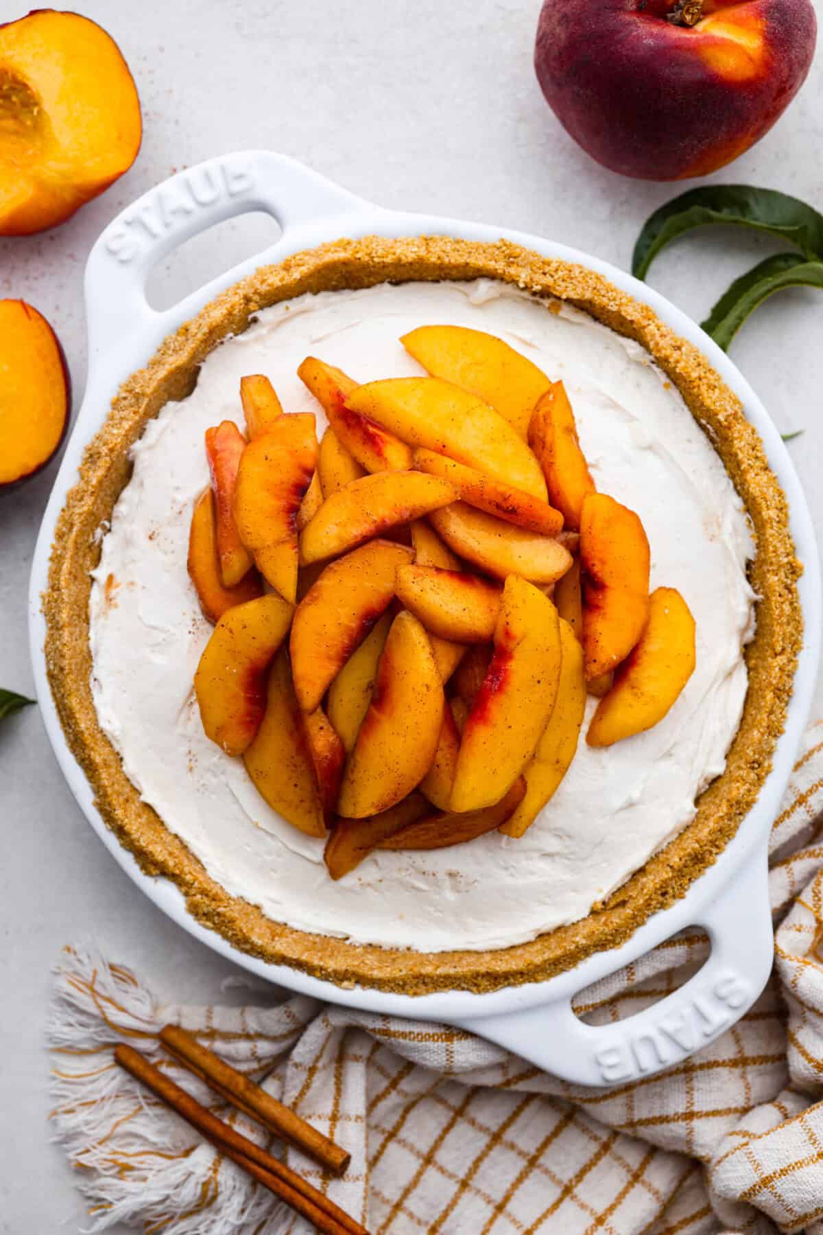 Enjoy juicy, ripe peaches in this Fresh Peach Pie. It has a creamy cheesecake filling topped with sweet peaches, all nestled in a buttery graham cracker crust. Itโs simply delightful, and no baking is required! Overhead shot of the no-bake fresh peach pie.
