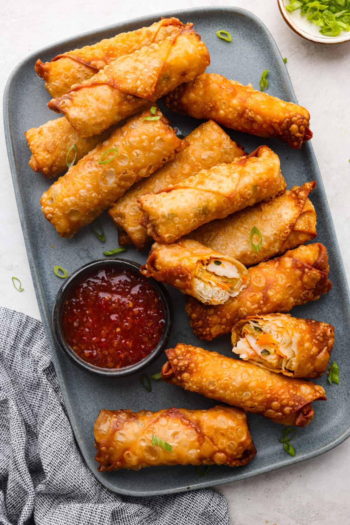 Crispy outside with a warm, flavorful filling, these Shrimp Egg Rolls are beyond delicious! They're packed with a mix of vermicelli noodles, sautéed veggies, shrimp and plenty of flavorings, then fried till crunchy and golden brown. Serve them as an appetizer, a light main or party side dish! Overhead shot of a plate full of fried shrimp egg rolls.