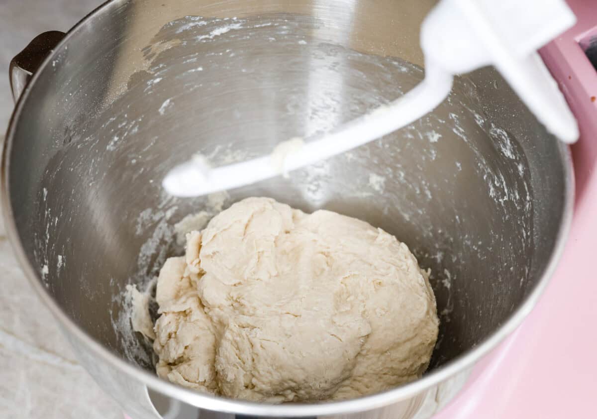 Bao Buns, or Baozi, are soft, pillowy buns made from a slightly sweet dough. They originate from China and are served with different types of fillings. You can enjoy them as a snack, as a side, or with dim sum. Angle shot of dough ball being formed in the bottom of a stand mixer.