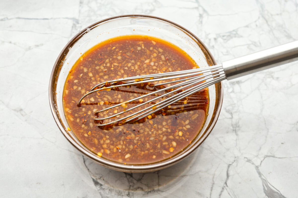 Kung Pao Beef is just like your favorite takeout but way tastier! This dish is loaded with flavor and so easy to make. Tender, marinated beef is stir-fried with veggies in a tangy, spicy Asian sauceย for an unforgettable meal! Overhead shot of sauce ingredients whisked together in a bowl.