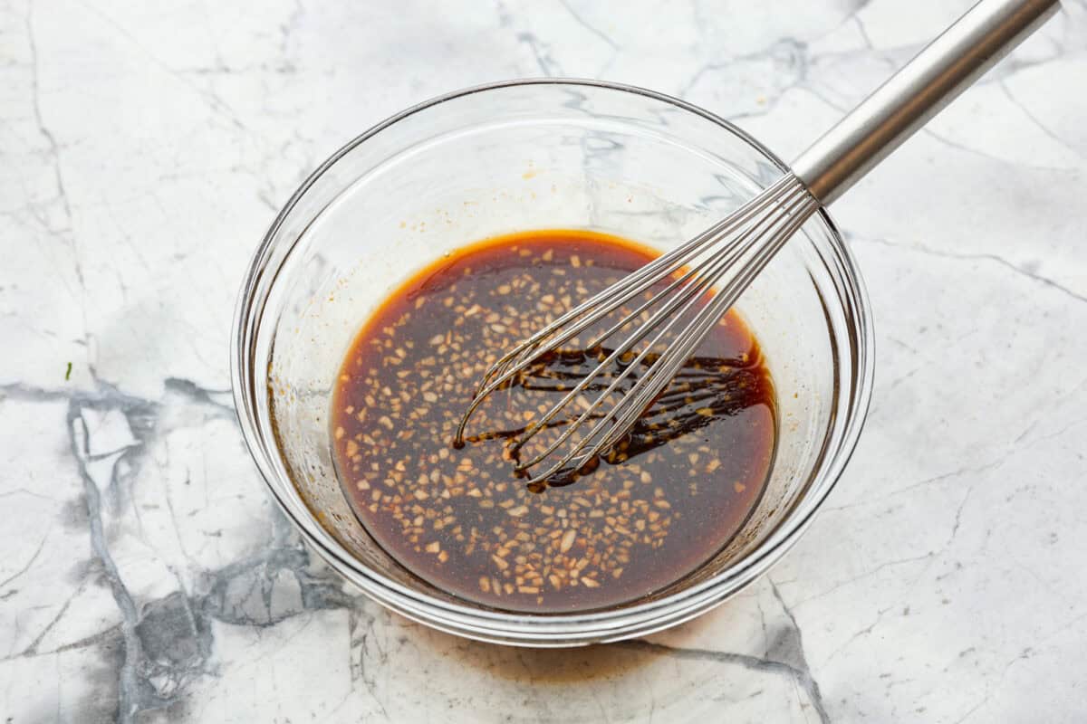 This simple air fryer pork belly recipe is great for making and enjoying this indulgent snack. It's meaty, crispy, smothered in a sticky, salty marinade that sets the flavors off perfectly! Overhead shot of marinade ingredients whisked in a bowl.