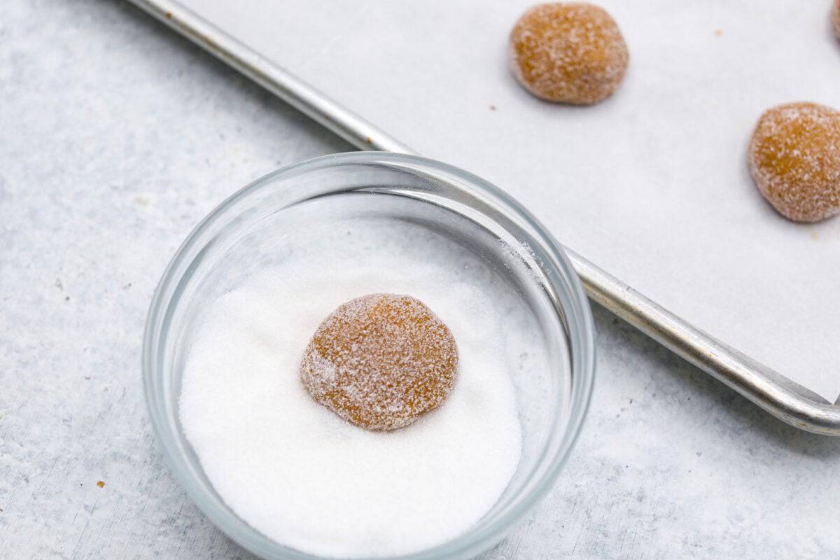 Browned Butter Sugar Cookies are irresistibly thick and chewy with rich flavor, thanks to the addition of browned butter. Even more delicious than the classic, and there's no need to chill the dough! Overhead shot of dough ball being rolled in sugar.