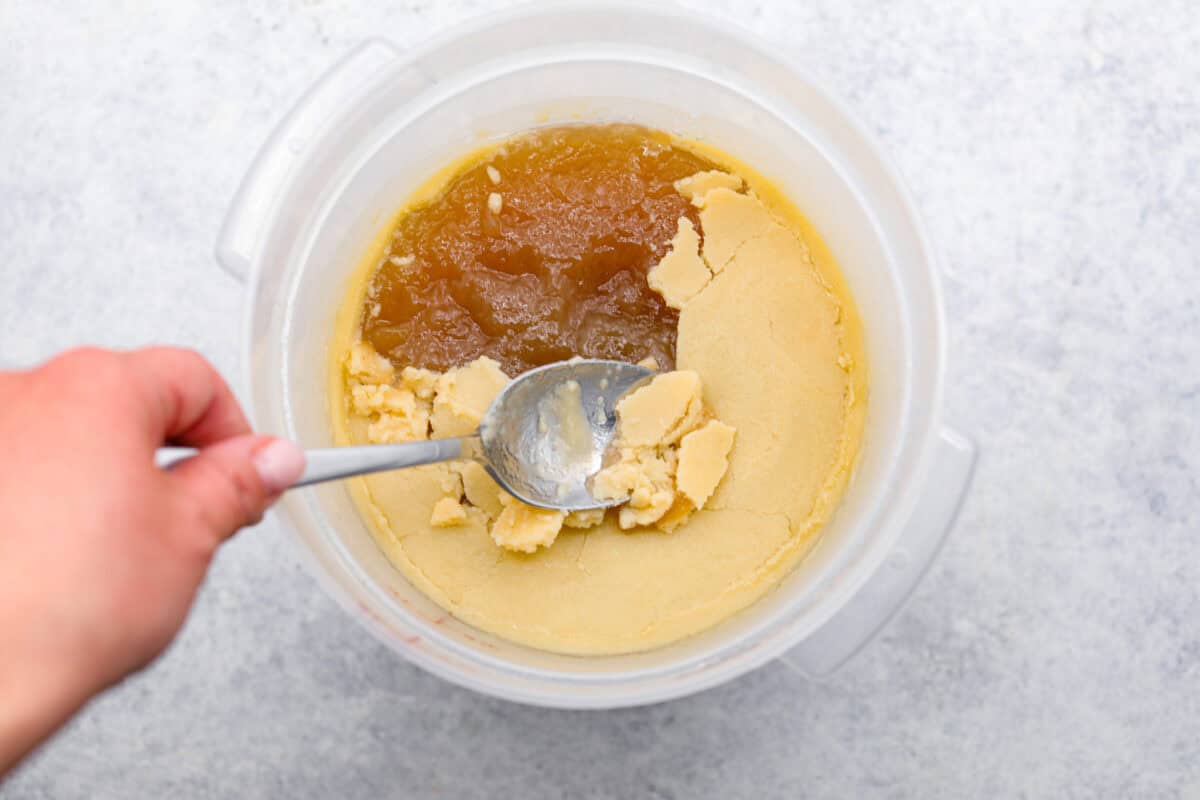Learn how to make homemade bone broth with all of my top tips and tricks! This easy recipe is a simple combination of wholesome, nutritious ingredients. It's freezer-friendly and great for using in a variety of recipes, from soups, sauces and gravies to casseroles and rice. Overhead shot of someone scraping the solidified fat from the top of the broth.