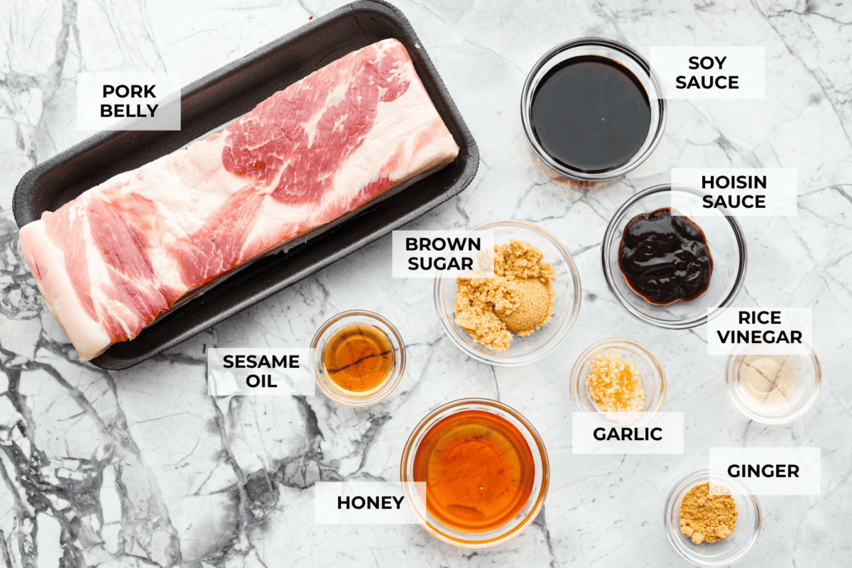 This simple air fryer pork belly recipe is great for making and enjoying this indulgent snack. It's meaty, crispy, smothered in a sticky, salty marinade that sets the flavors off perfectly! Overhead shot of labeled ingredients.