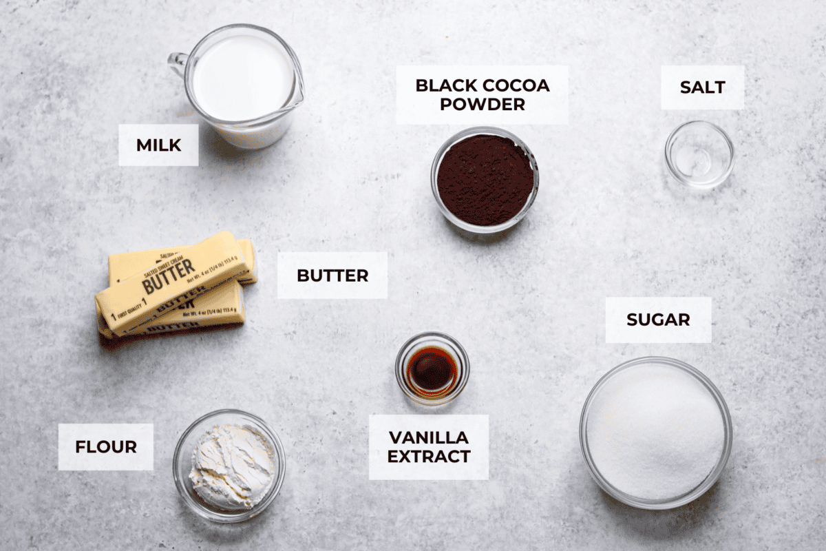 This delicious black frosting is fun to make for special occasions, especially for Halloween, seasonal treats, and desserts. It's made with black cocoa powder, which tastes just like Oreo's! The best part is that it won't dye your mouth, hands, or clothing! It's the perfect frosting for witchy cakes and other dramatic parties. Overhead shot of labeled ingredients.