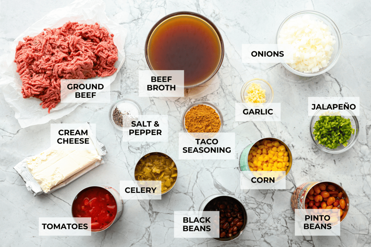 This creamy taco soup recipe is full of fresh flavors, tender vegetables, and hearty beans. The seasoned beef mixed with the creamy soup is out of this world good! Top it with your favorite toppings, and your family will love this warm, savory soup! Overhead shot of labeled ingredients.