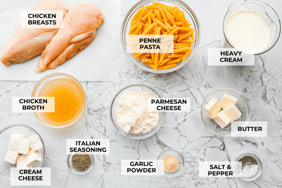 This crockpot chicken alfredo is a family dinner that's packed with flavor! The juicy, tender chicken cooked with creamy, cheesy pasta simply can't be beat! Plus, it’s super easy when your crock pot does all the work! Overhead shot of labeled ingredients.