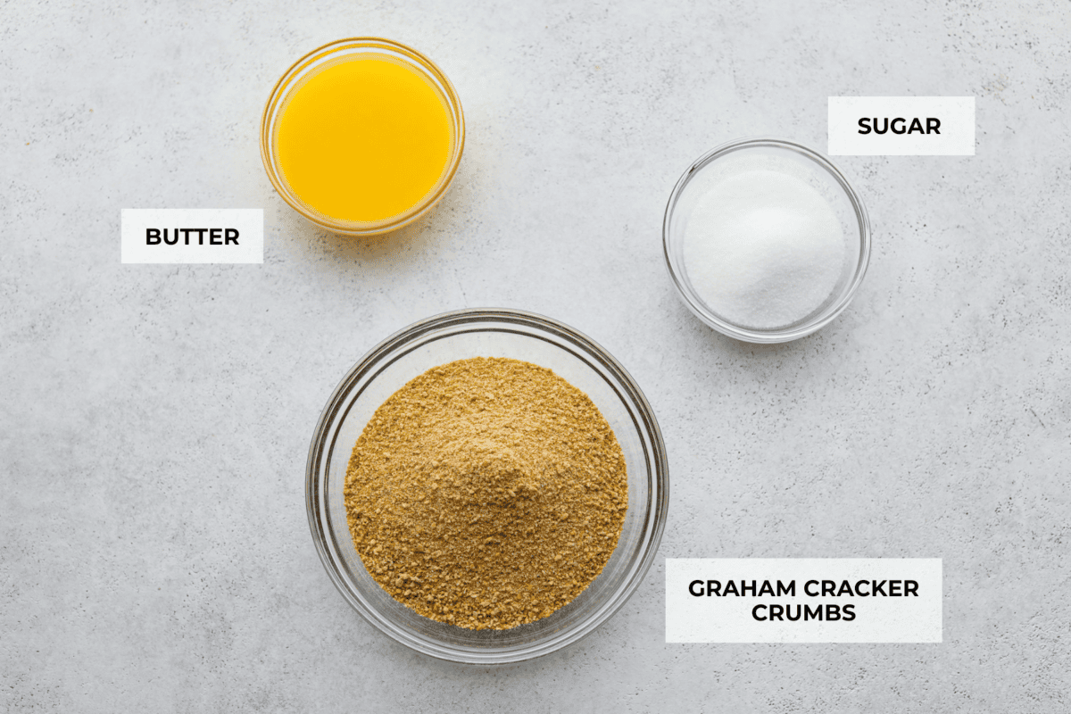 Learn how to make the perfect homemade Graham Cracker Crust! It comes together in just 10 minutes with 3 simple ingredients for the right amount of buttery sweetness and crunch!ย Youโll never buy one from the store again! Overhead shot of labeled ingredients.
