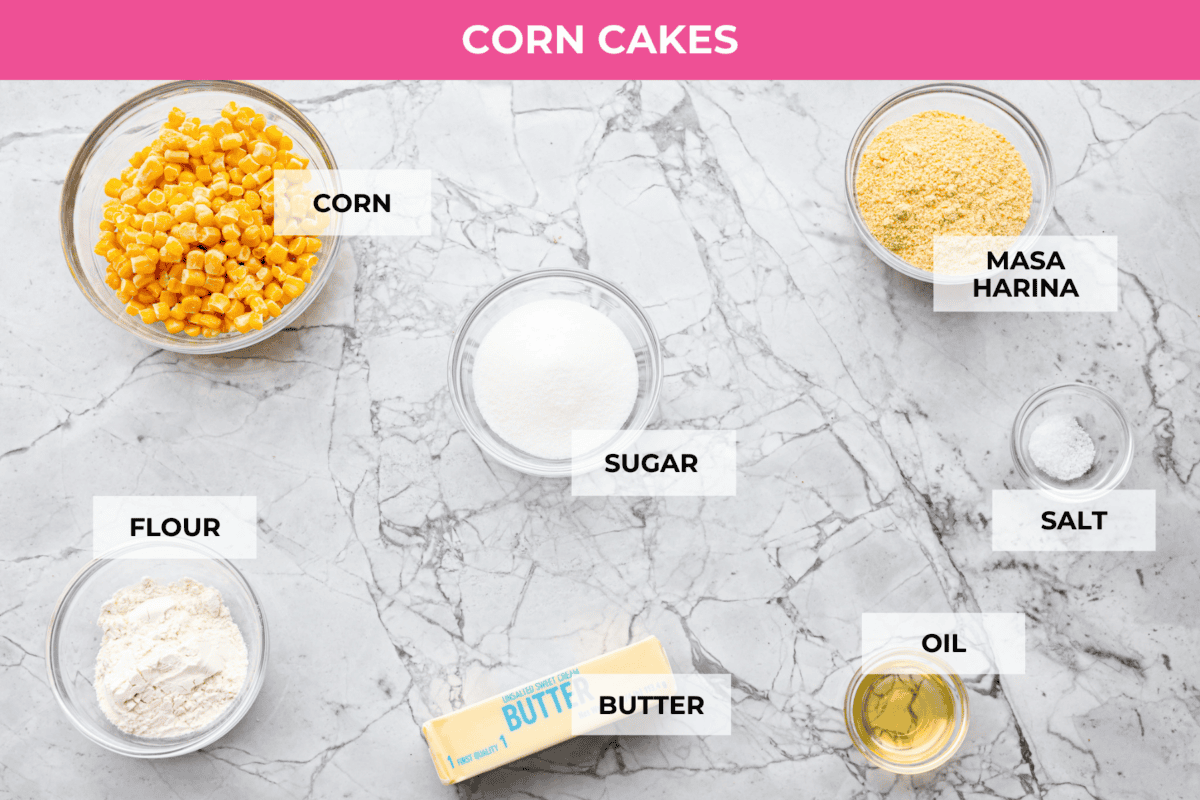 Homemade Sweet Corn Tamale Cakes are an explosion of delicious flavor in every bite! With this easy recipe you can bring this Cheesecake Factory favorite right to your own kitchen. Add the signature topping to really take these to the next level! Overhead shot of labeled corn cakes ingredients.