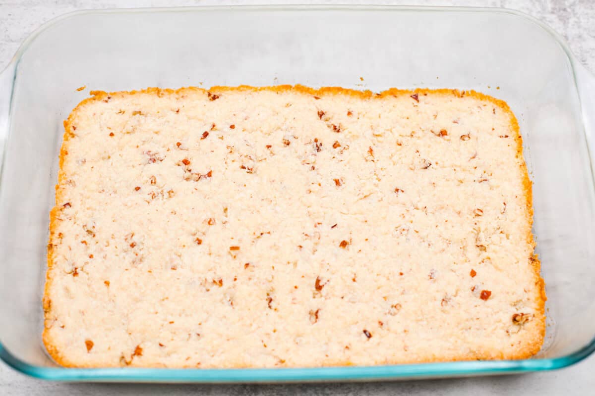 Fall in love with this Pumpkin Delight! A shortbread crust topped with a fluffy cheesecake mixture, a creamy pumpkin layer, and whipped topping. Every bite of this irresistible layered dessert is pumpkin heaven! Second photo of the crust baked in the pan.