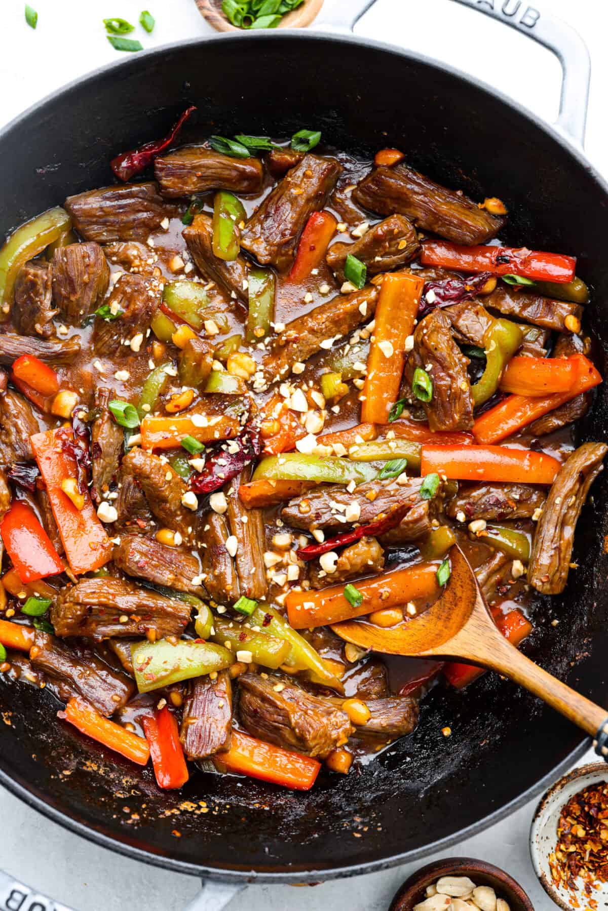 Kung Pao Beef is just like your favorite takeout but way tastier! This dish is loaded with flavor and so easy to make. Tender, marinated beef is stir-fried with veggies in a tangy, spicy Asian sauceย for an unforgettable meal! Overhead shot of Kung Pao Beef cooked in a wok.